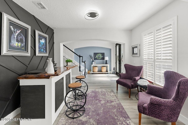 11698 Donato Dr, Jacksonville, FL 32226 - living area featuring arched walkways, a fireplace, wood finished floors, and stairs