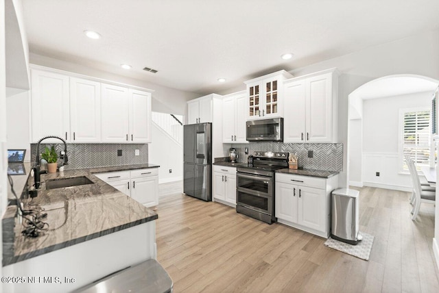 11698 Donato Dr, Jacksonville, FL 32226 - kitchen with stainless steel appliances, a sink, arched walkways, light wood finished floors, and recessed lighting