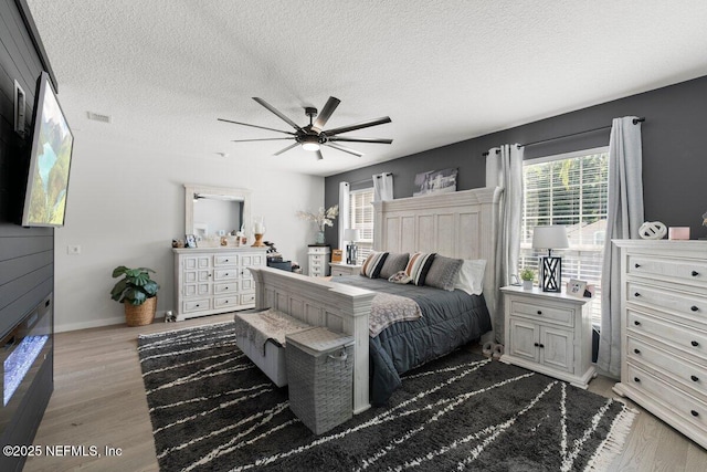 11698 Donato Dr, Jacksonville, FL 32226 - bedroom with multiple windows, a textured ceiling, wood finished floors, baseboards, and ceiling fan