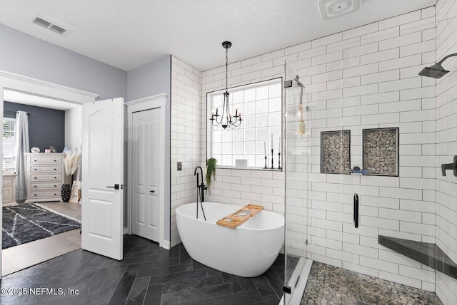 11698 Donato Dr, Jacksonville, FL 32226 - full bathroom with a stall shower, a soaking tub, a chandelier, and a textured ceiling