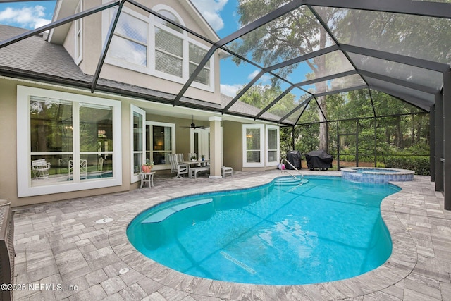 view of swimming pool featuring a patio area, ceiling fan, a lanai, and a pool with connected hot tub