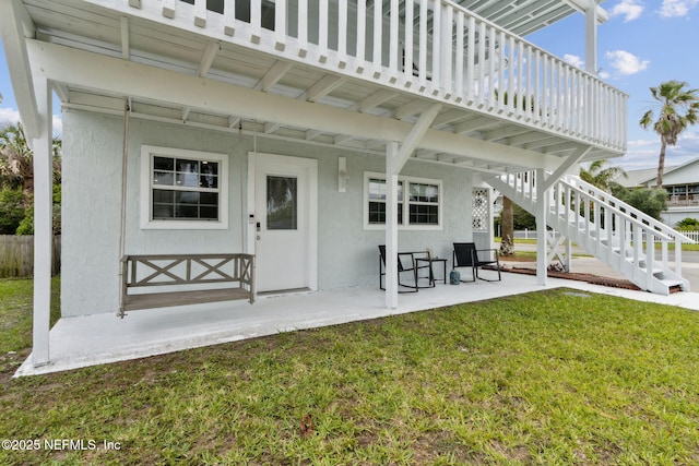 2902 W 5th St, Fernandina Beach, FL 32034 - rear view of property featuring a patio, stairway, and stucco siding