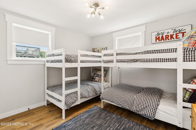 2902 W 5th St, Fernandina Beach, FL 32034 - bedroom with wood finished floors, a chandelier, and baseboards