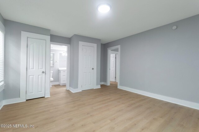 3321 Deason Ave, Jacksonville, FL 32254 - unfurnished bedroom with baseboards, light wood-type flooring, and connected bathroom