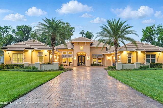120 Hallowes Cv, Saint Johns, FL 32259 - mediterranean / spanish-style house featuring decorative driveway, a front yard, french doors, stucco siding, and a tile roof