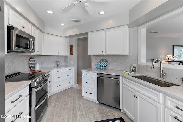 91 San Juan Dr Unit H8, Ponte Vedra Beach, FL 32082 - kitchen featuring appliances with stainless steel finishes, a sink, white cabinetry, ceiling fan, and decorative backsplash