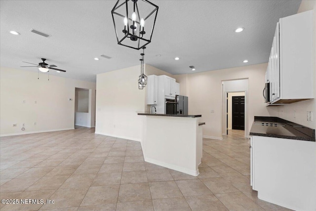 3357 Pegaso Ave, New Smyrna Beach, FL 32168 - kitchen with dark countertops, white cabinetry, a ceiling fan, light tile patterned floors, and decorative light fixtures