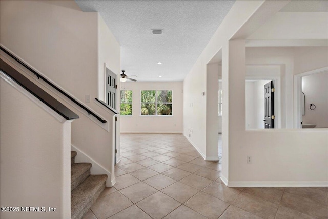 3357 Pegaso Ave, New Smyrna Beach, FL 32168 - entryway with light tile patterned floors, stairway, a ceiling fan, a textured ceiling, and baseboards