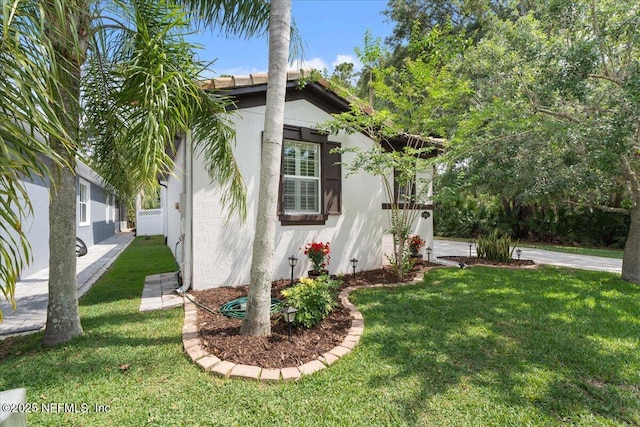 3357 Pegaso Ave, New Smyrna Beach, FL 32168 - view of side of home featuring stucco siding and a lawn