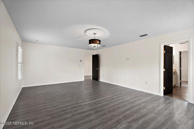 3357 Pegaso Ave, New Smyrna Beach, FL 32168 - spare room featuring dark wood-style floors, a textured ceiling, and baseboards