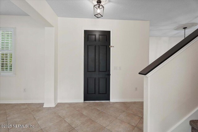 3357 Pegaso Ave, New Smyrna Beach, FL 32168 - entryway with stairway, baseboards, and light tile patterned flooring