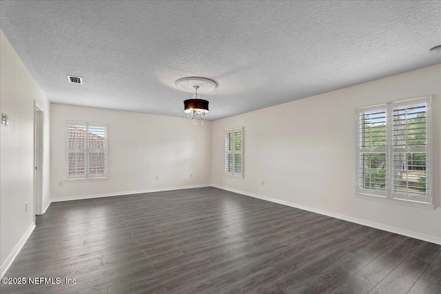 3357 Pegaso Ave, New Smyrna Beach, FL 32168 - unfurnished room with dark wood-style flooring, plenty of natural light, baseboards, and a textured ceiling