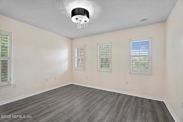 3357 Pegaso Ave, New Smyrna Beach, FL 32168 - spare room featuring dark wood-style flooring, a textured ceiling, plenty of natural light, and baseboards