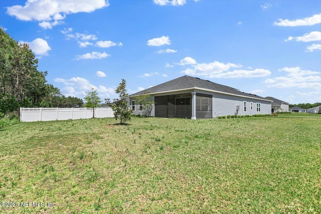 view of yard with a sunroom and fence