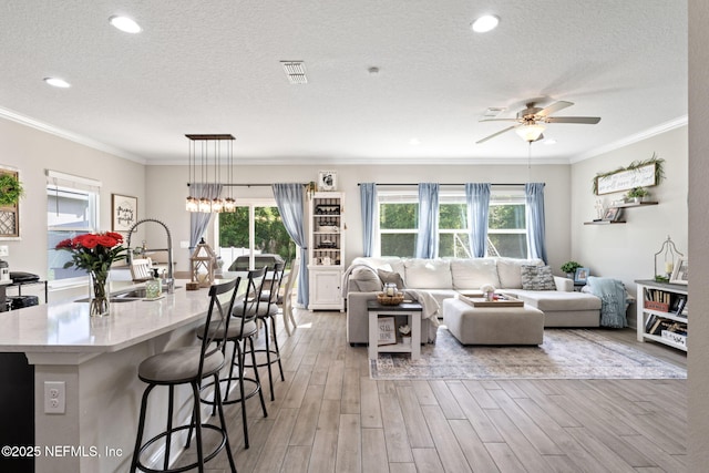 2565 Cold Stream Ln, Green Cove Springs, FL 32043 - living room featuring plenty of natural light, light wood-type flooring, ceiling fan, a textured ceiling, and ornamental molding