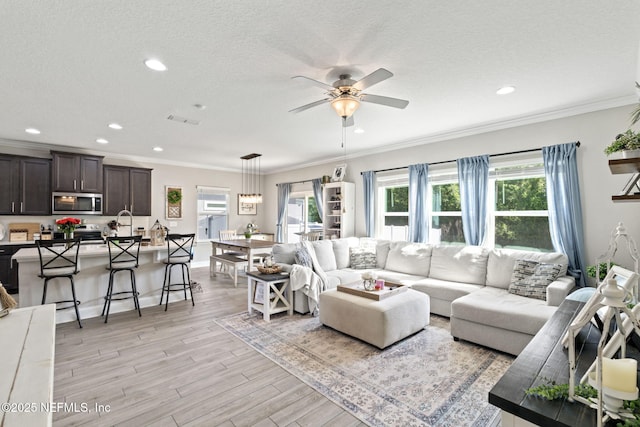 2565 Cold Stream Ln, Green Cove Springs, FL 32043 - living room featuring a ceiling fan, recessed lighting, light wood-type flooring, a textured ceiling, and ornamental molding