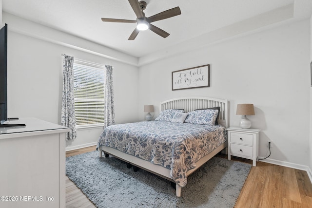 bedroom featuring light wood-style flooring, baseboards, and a ceiling fan