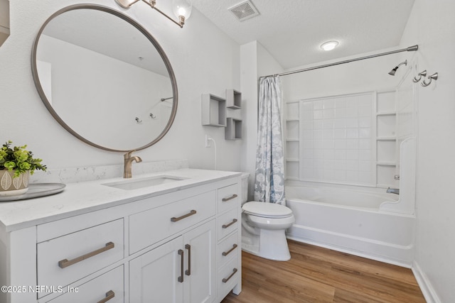 full bath featuring wood finished floors, toilet, a textured ceiling, shower / bathtub combination with curtain, and vanity