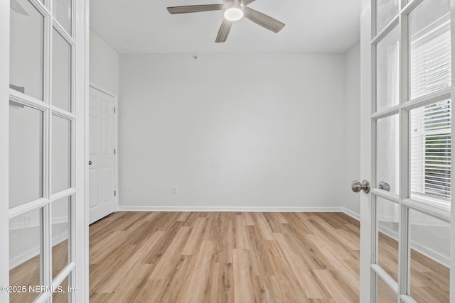 spare room with ceiling fan, light wood-style floors, baseboards, and french doors