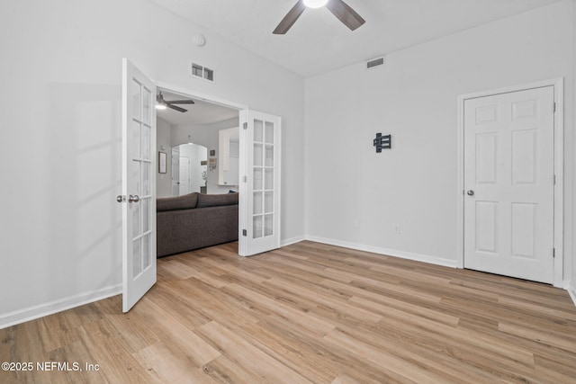 empty room featuring french doors, ceiling fan, light wood-style floors, arched walkways, and baseboards