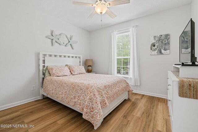 bedroom with light wood-type flooring, baseboards, and ceiling fan