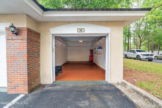 garage featuring asphalt driveway