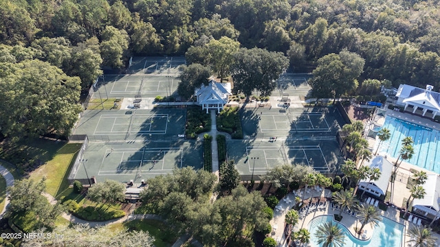 bird's eye view of a pool area and a heavily wooded area
