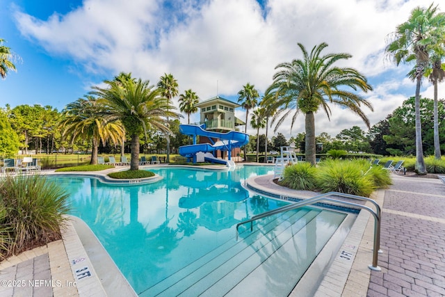 community pool featuring a water slide and a patio