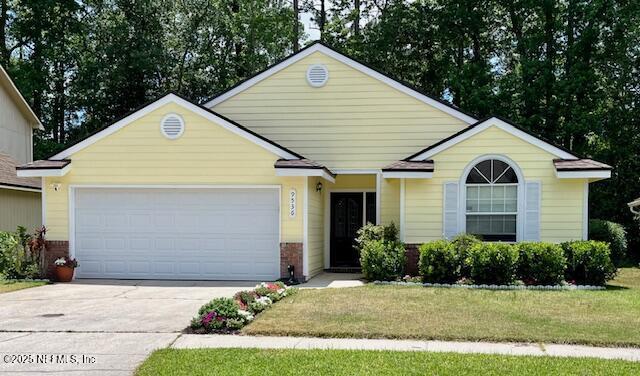 9536 Glenn Abbey Way, Jacksonville, FL 32256 - view of front of house featuring driveway, a garage, a front lawn, and brick siding