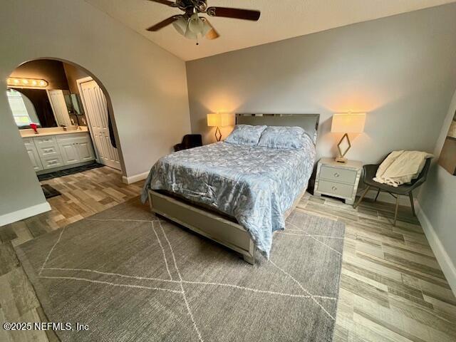 9536 Glenn Abbey Way, Jacksonville, FL 32256 - bedroom featuring arched walkways, wood finished floors, baseboards, lofted ceiling, and ensuite bathroom