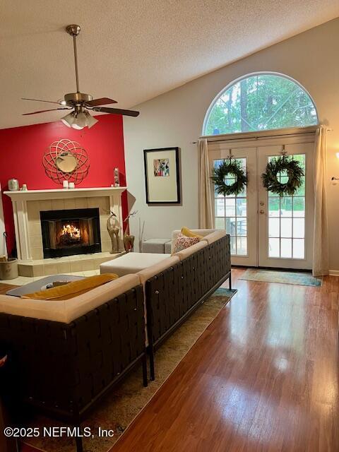 9536 Glenn Abbey Way, Jacksonville, FL 32256 - living room featuring a tiled fireplace, wood finished floors, a textured ceiling, and a ceiling fan