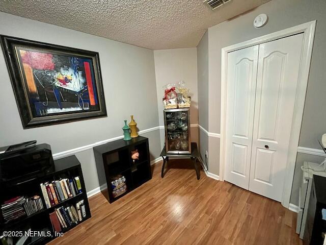 9536 Glenn Abbey Way, Jacksonville, FL 32256 - sitting room with wood finished floors, a textured ceiling, baseboards, and wine cooler