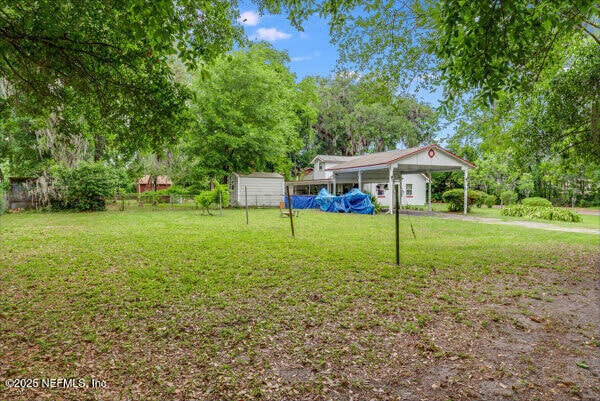 2760 Jerry Ln, Jacksonville, FL 32218 - view of grassy yard with a carport and view of wooded area
