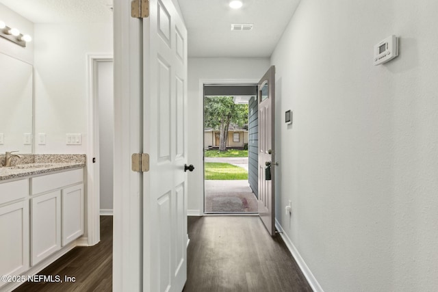 8468 Buttercup St, Jacksonville, FL 32210 - doorway to outside featuring dark wood-style flooring, a sink, and baseboards