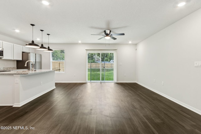 8468 Buttercup St, Jacksonville, FL 32210 - unfurnished living room featuring a ceiling fan, dark wood-style flooring, recessed lighting, baseboards, and a sink