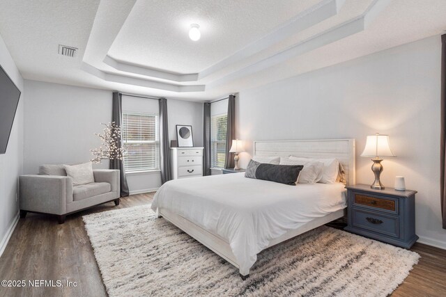 1309 Foxmeadow Trl, Middleburg, FL 32068 - bedroom featuring baseboards, a tray ceiling, wood finished floors, and a textured ceiling