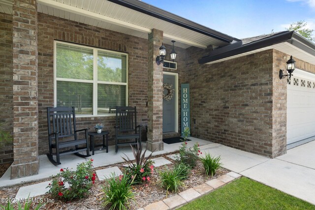 1309 Foxmeadow Trl, Middleburg, FL 32068 - view of exterior entry featuring covered porch, a garage, and brick siding
