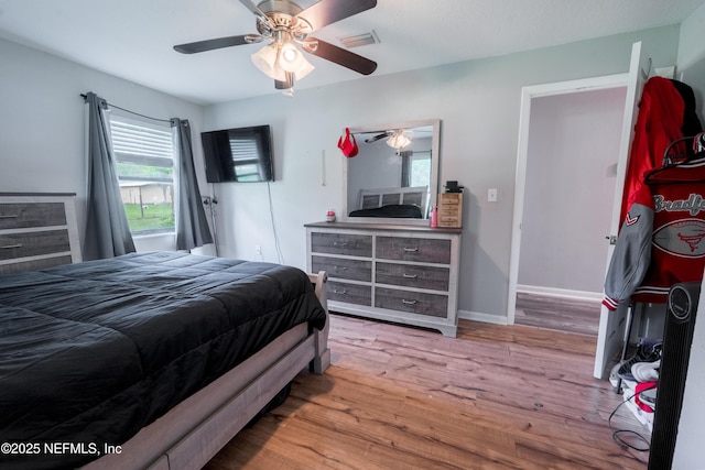 bedroom featuring wood finished floors, a ceiling fan, and baseboards