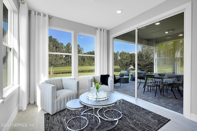 sunroom featuring plenty of natural light, an outdoor hangout area, and outdoor dining area