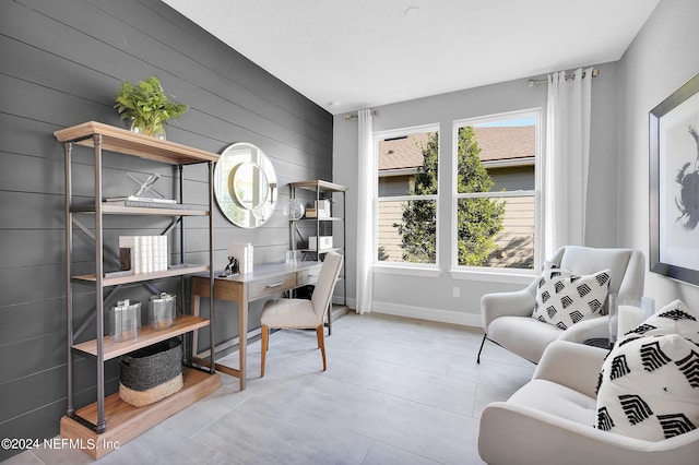 tiled home office featuring wooden walls and baseboards