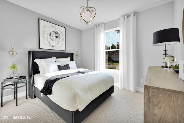bedroom featuring light colored carpet, baseboards, and a chandelier