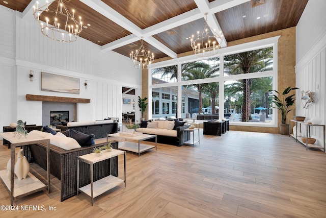 living room featuring a chandelier, a towering ceiling, wood ceiling, and a fireplace