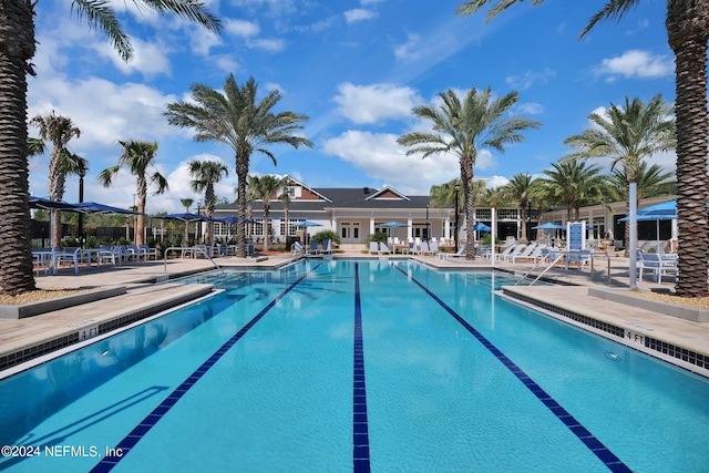 community pool with a patio area and fence