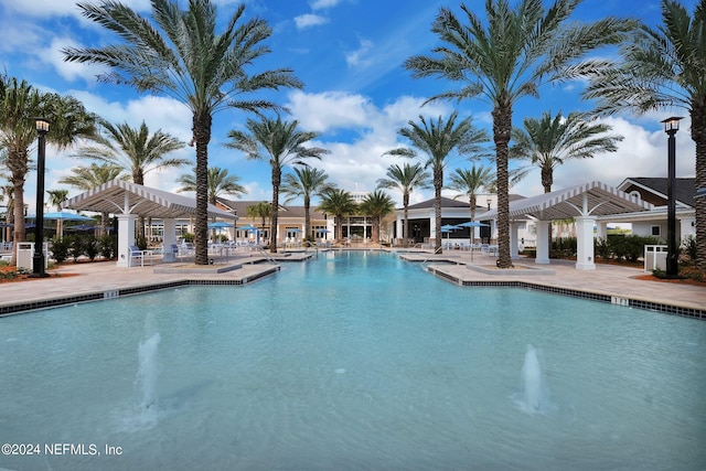 community pool with a pergola and a patio area