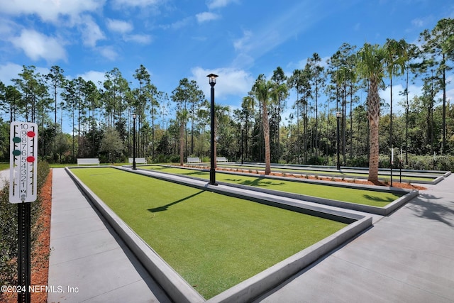 view of home's community featuring a game area and view of wooded area