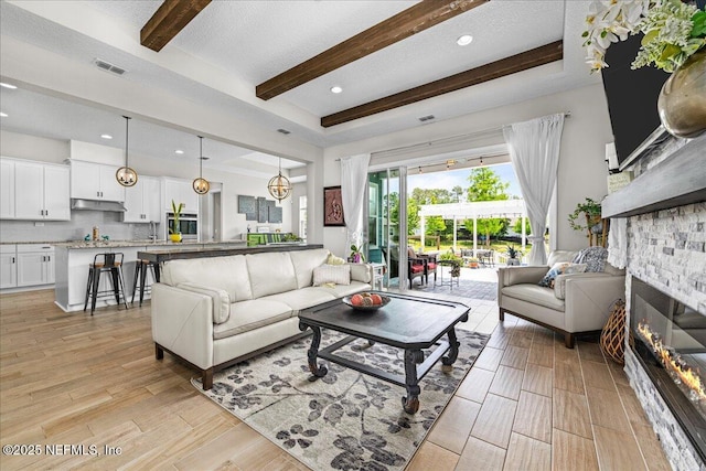 71 Lansing Ct, Saint Augustine, FL 32092 - living area featuring beamed ceiling, light wood-style floors, a stone fireplace, and recessed lighting