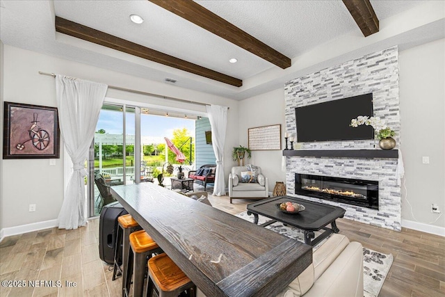 71 Lansing Ct, Saint Augustine, FL 32092 - living area featuring beamed ceiling, a stone fireplace, baseboards, a textured ceiling, and wood finished floors