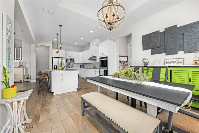 71 Lansing Ct, Saint Augustine, FL 32092 - dining space featuring a chandelier, light wood finished floors, a textured ceiling, recessed lighting, and baseboards