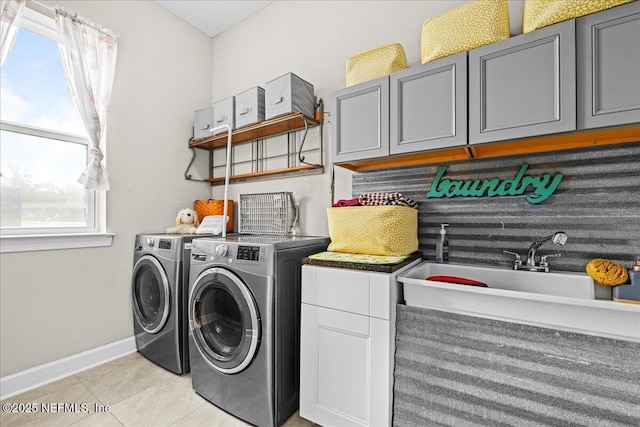 71 Lansing Ct, Saint Augustine, FL 32092 - laundry area featuring cabinet space, washer and dryer, light tile patterned floors, and baseboards