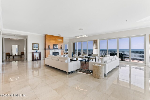 living room featuring crown molding, a water view, and plenty of natural light